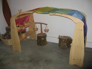 A classic Waldorf playspace - covered with a rainbow silk. I think the stands can be made easily.